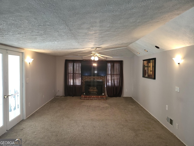 unfurnished living room with a fireplace, a textured ceiling, carpet, and a wealth of natural light