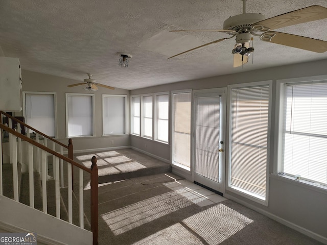 unfurnished sunroom with ceiling fan