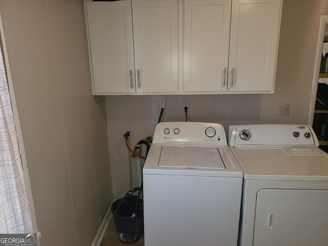 clothes washing area featuring cabinets and independent washer and dryer