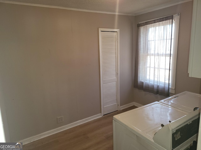 clothes washing area featuring crown molding, independent washer and dryer, and hardwood / wood-style floors