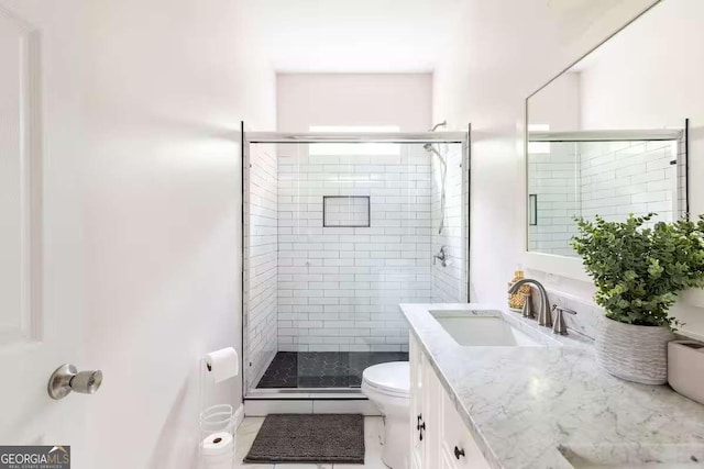 bathroom featuring vanity, an enclosed shower, and toilet