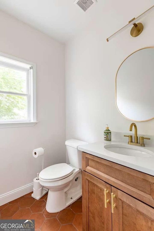 bathroom with tile patterned flooring, vanity, and toilet