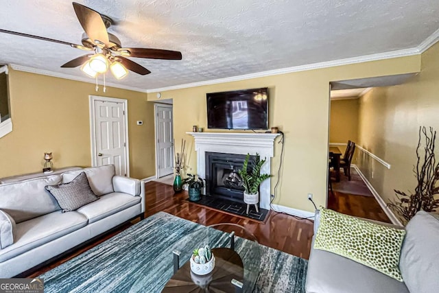 living room featuring crown molding, ceiling fan, dark hardwood / wood-style floors, and a textured ceiling