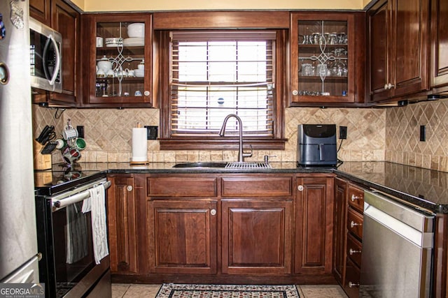 kitchen with appliances with stainless steel finishes, sink, dark brown cabinets, and decorative backsplash