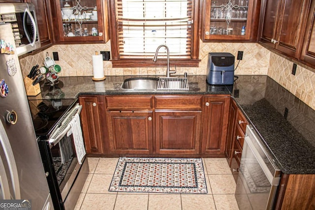 kitchen featuring sink, light tile patterned floors, backsplash, and appliances with stainless steel finishes