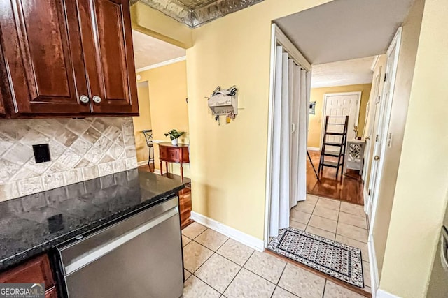 kitchen featuring dishwasher, light tile patterned floors, backsplash, and crown molding