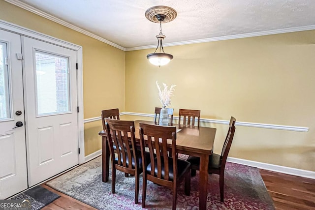 dining area featuring hardwood / wood-style flooring and ornamental molding