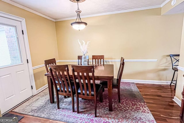 dining space with dark wood-type flooring and ornamental molding