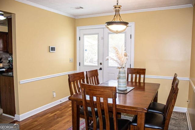 dining area featuring ornamental molding and dark hardwood / wood-style floors