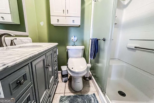 bathroom with vanity, toilet, tile patterned flooring, and a shower with door