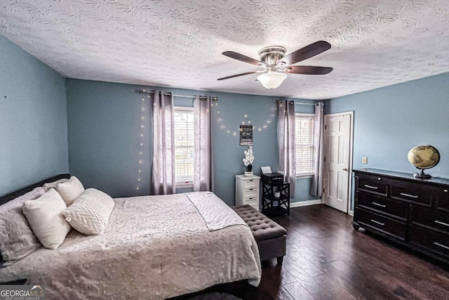 bedroom with ceiling fan, dark hardwood / wood-style floors, and a textured ceiling