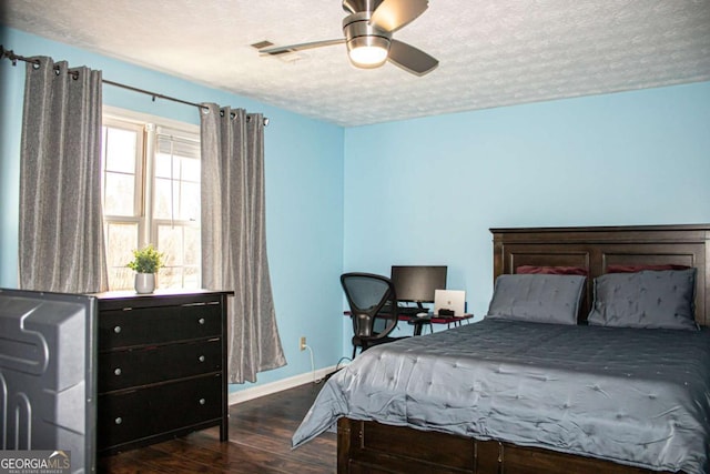 bedroom with dark hardwood / wood-style flooring, ceiling fan, and a textured ceiling