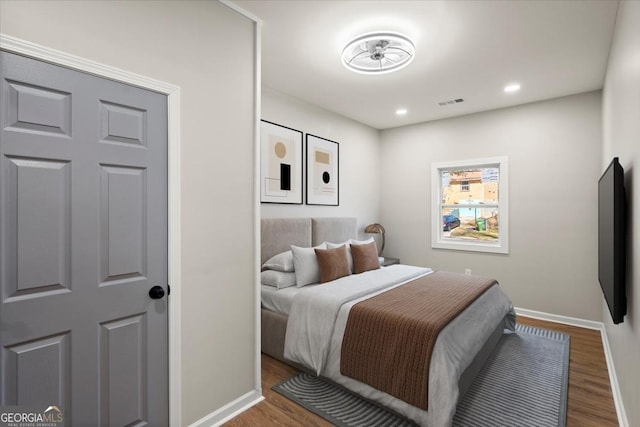 bedroom with dark hardwood / wood-style floors