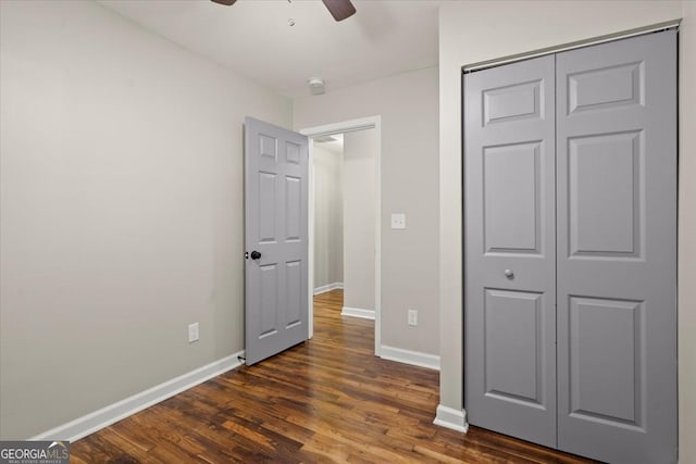 unfurnished bedroom featuring a closet, dark hardwood / wood-style floors, and ceiling fan