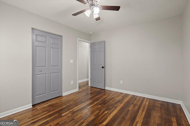 unfurnished bedroom with dark hardwood / wood-style flooring, ceiling fan, and a closet