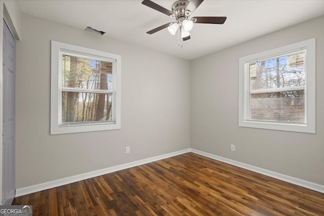 spare room with dark wood-type flooring and ceiling fan