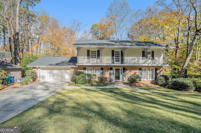 view of front property featuring a garage, a balcony, and a front yard