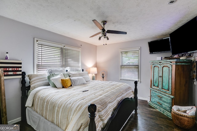 bedroom featuring a textured ceiling, dark wood-type flooring, and ceiling fan