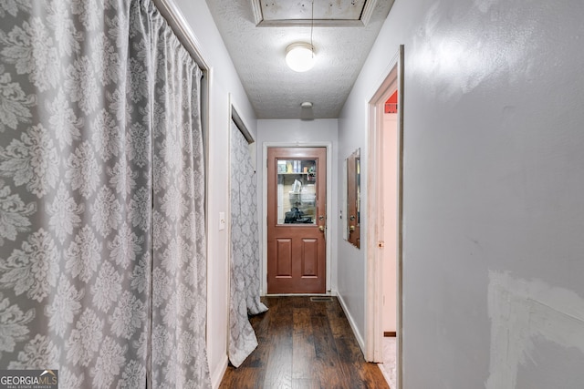 hall with dark hardwood / wood-style floors and a textured ceiling