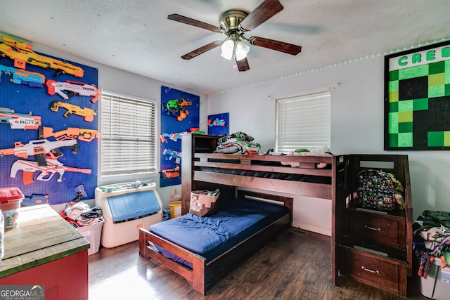 bedroom featuring dark hardwood / wood-style flooring, a textured ceiling, and ceiling fan