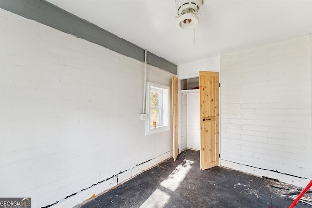 unfurnished bedroom featuring brick wall