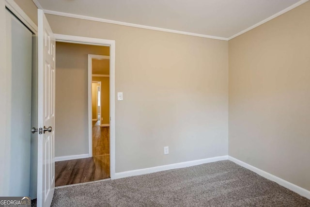 carpeted empty room featuring crown molding