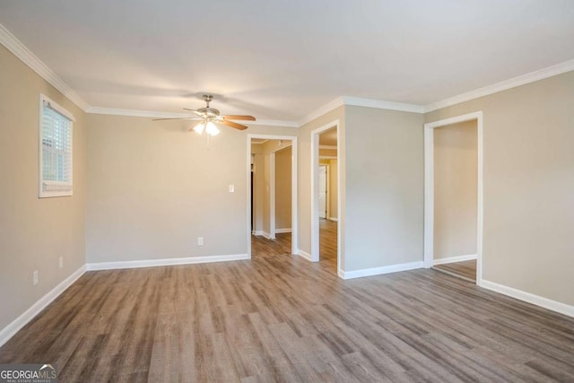 empty room with crown molding, ceiling fan, and wood-type flooring