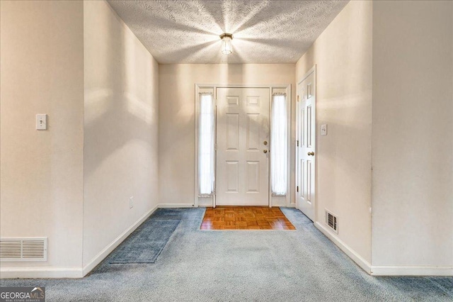 carpeted entryway featuring a textured ceiling