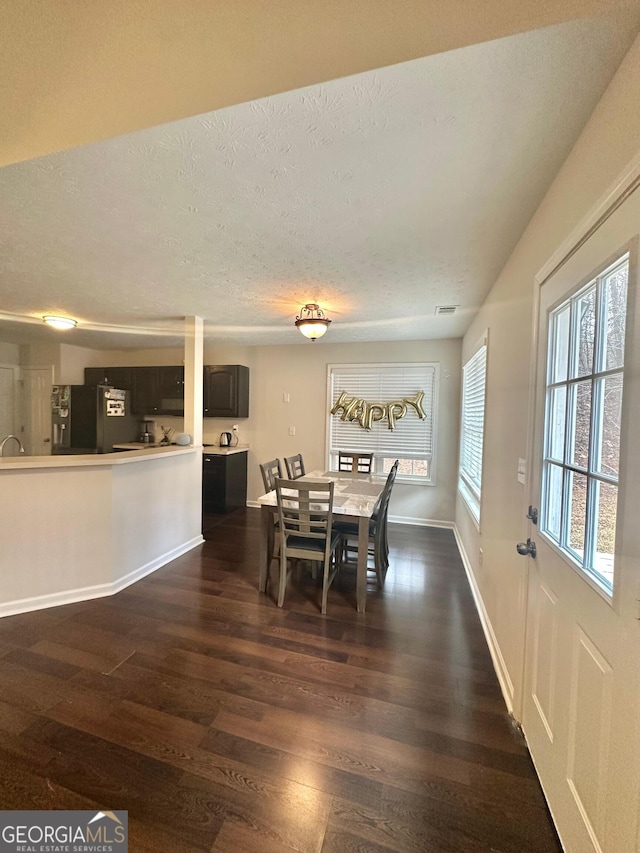 dining area with dark hardwood / wood-style floors and a textured ceiling