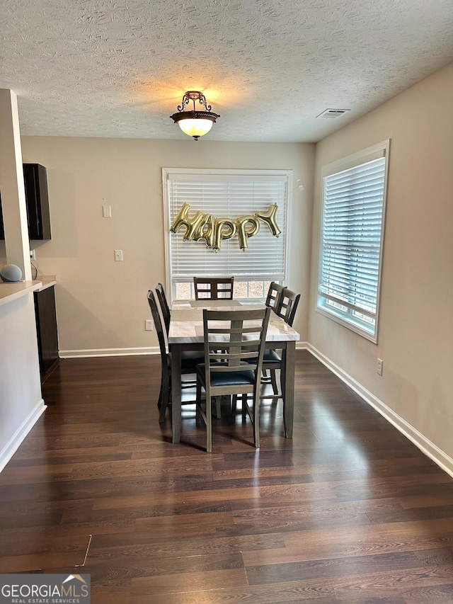 dining room with dark hardwood / wood-style flooring and a textured ceiling