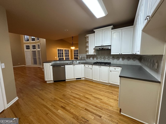 kitchen with white cabinetry, appliances with stainless steel finishes, kitchen peninsula, and tasteful backsplash