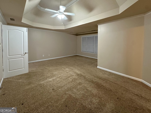 carpeted empty room with crown molding, a raised ceiling, and ceiling fan