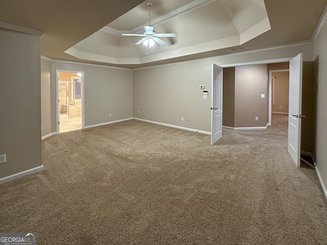 empty room with crown molding, carpet, ceiling fan, and a tray ceiling