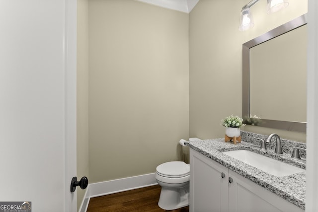 bathroom featuring vanity, hardwood / wood-style floors, and toilet