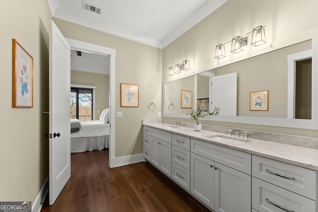 bathroom featuring vanity, hardwood / wood-style flooring, and ornamental molding