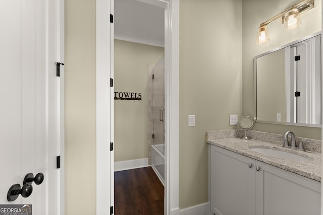 bathroom featuring hardwood / wood-style flooring, vanity, and tiled shower / bath combo