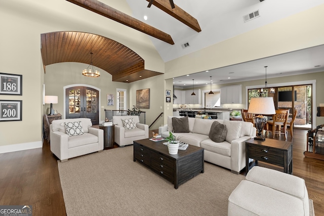 living room featuring french doors, lofted ceiling, light wood-type flooring, and a notable chandelier