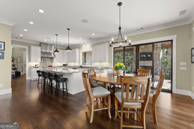 dining area with ornamental molding, dark hardwood / wood-style floors, a chandelier, and sink