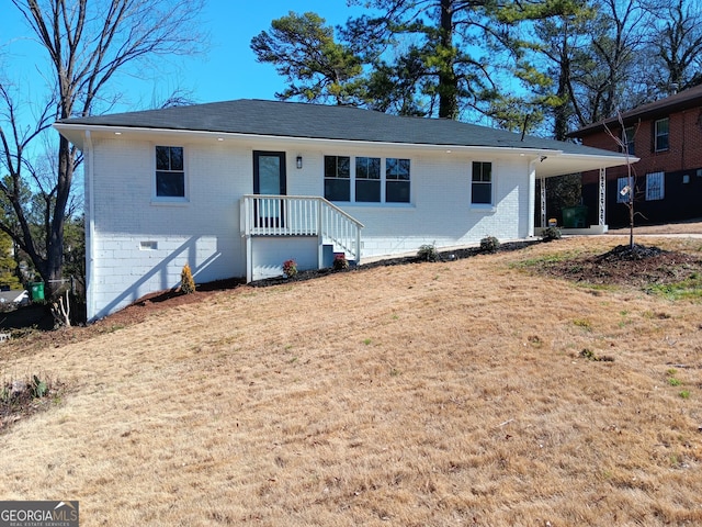 view of front facade with a carport and a front lawn