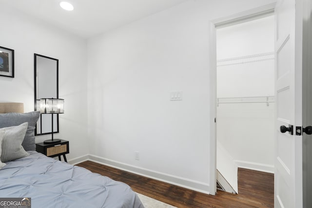 bedroom with dark hardwood / wood-style flooring and a closet