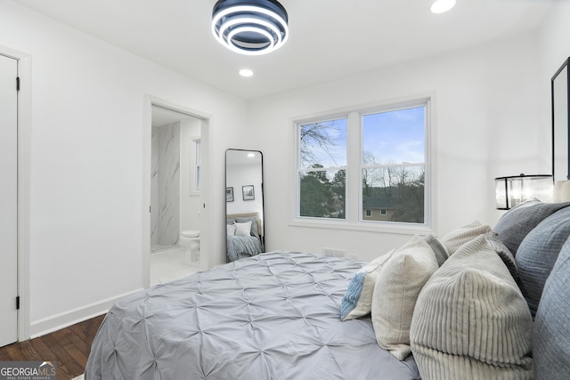 bedroom with connected bathroom and dark hardwood / wood-style flooring