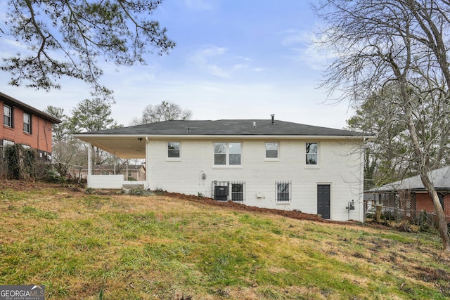 rear view of house with a yard and central AC