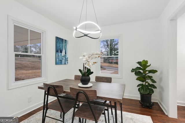 dining area featuring an inviting chandelier and dark wood-type flooring