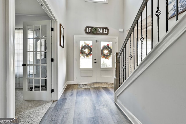 foyer entrance featuring a healthy amount of sunlight, dark wood-type flooring, and french doors