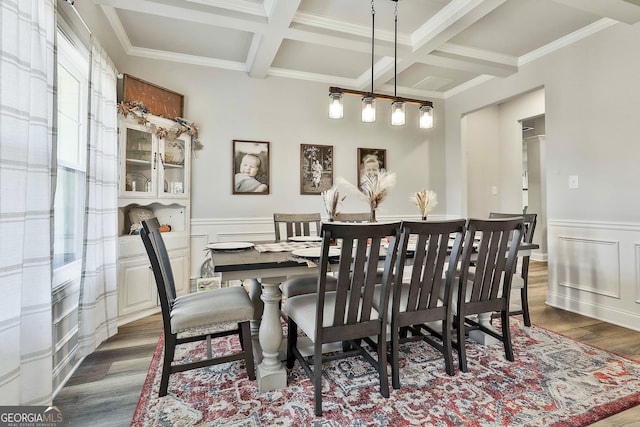 dining space featuring dark hardwood / wood-style floors, ornamental molding, coffered ceiling, and beam ceiling