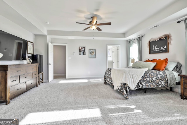 bedroom featuring ensuite bath, light colored carpet, and ceiling fan