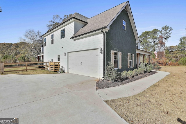 view of side of property featuring a garage and a lawn