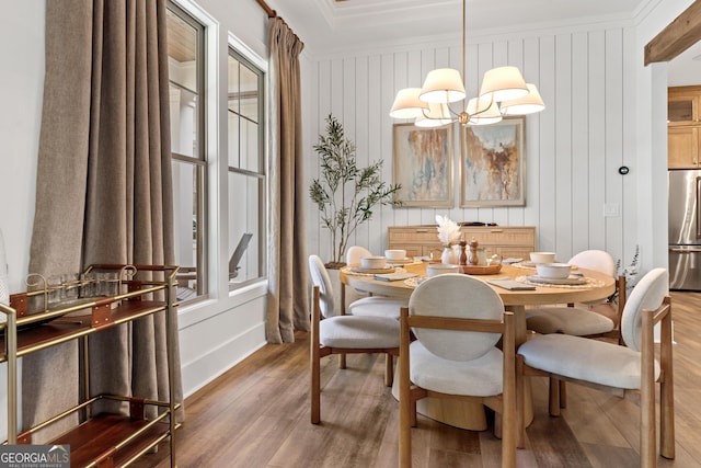 dining room featuring crown molding, an inviting chandelier, and wood finished floors