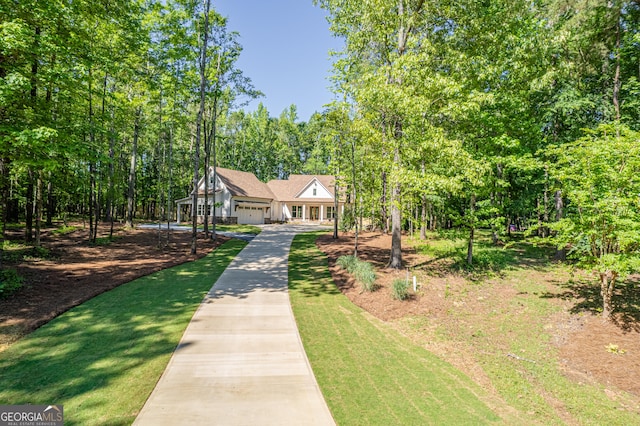 view of front of house featuring an attached garage, concrete driveway, and a front yard