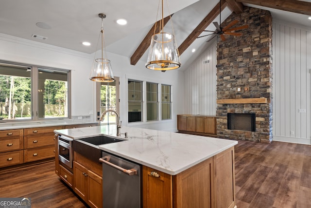 kitchen with open floor plan, stainless steel dishwasher, brown cabinets, an island with sink, and decorative light fixtures